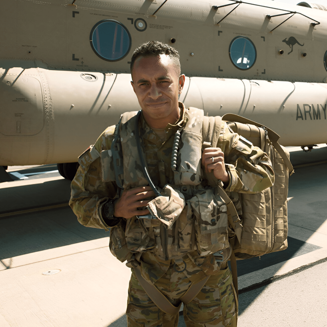 Medic Murray stands in front of an aircraft with a back pack.