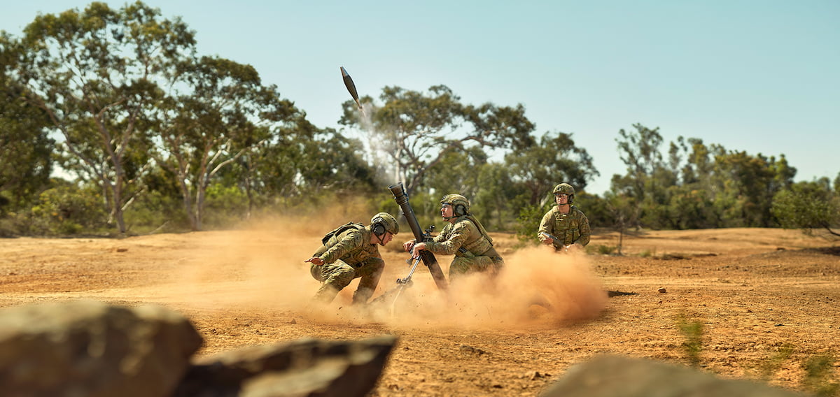 Members of the Army engaging with a rocket, showcasing camaraderie and teamwork.