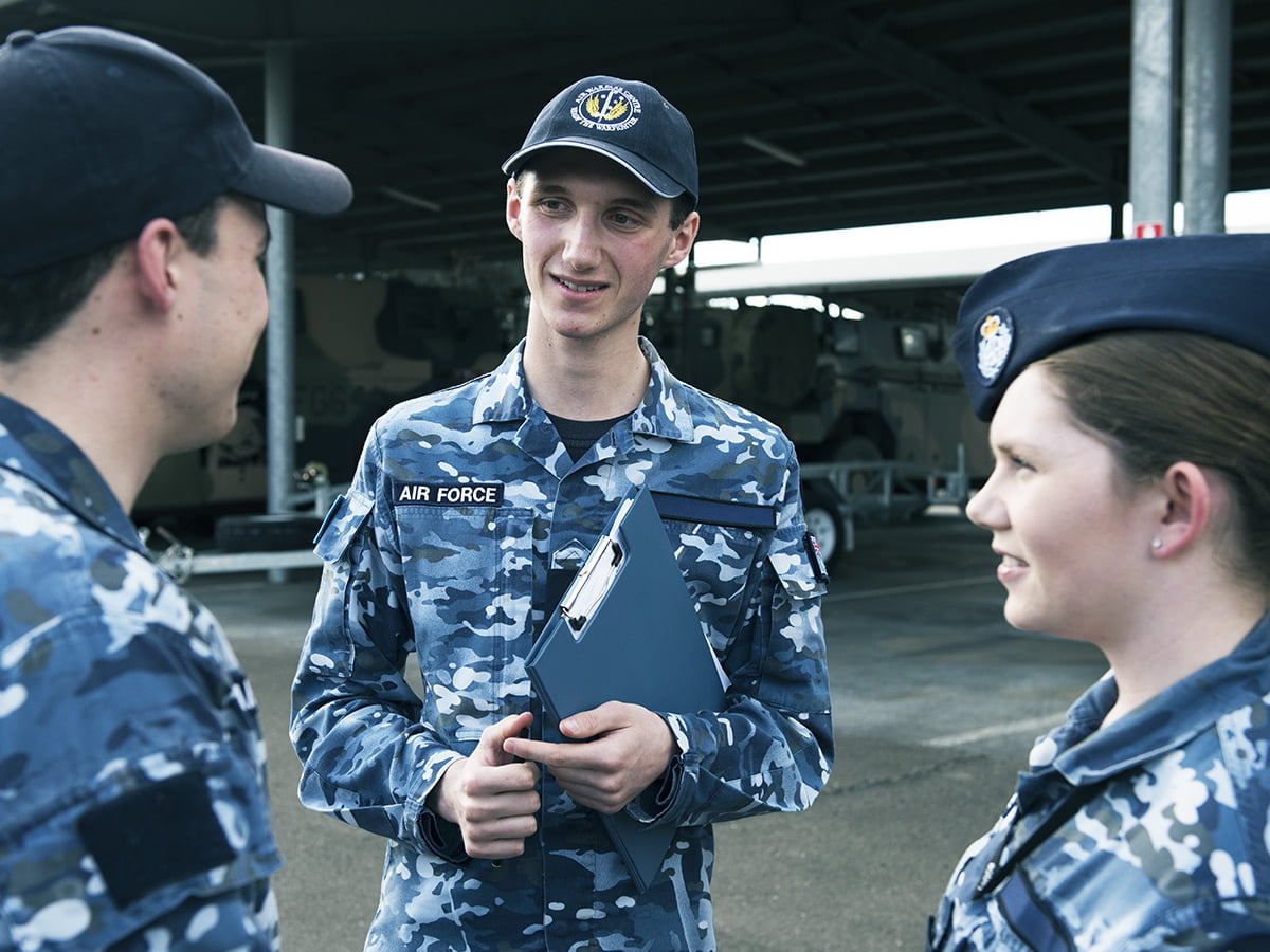 A member of the Air Force is in conversation with two colleagues.