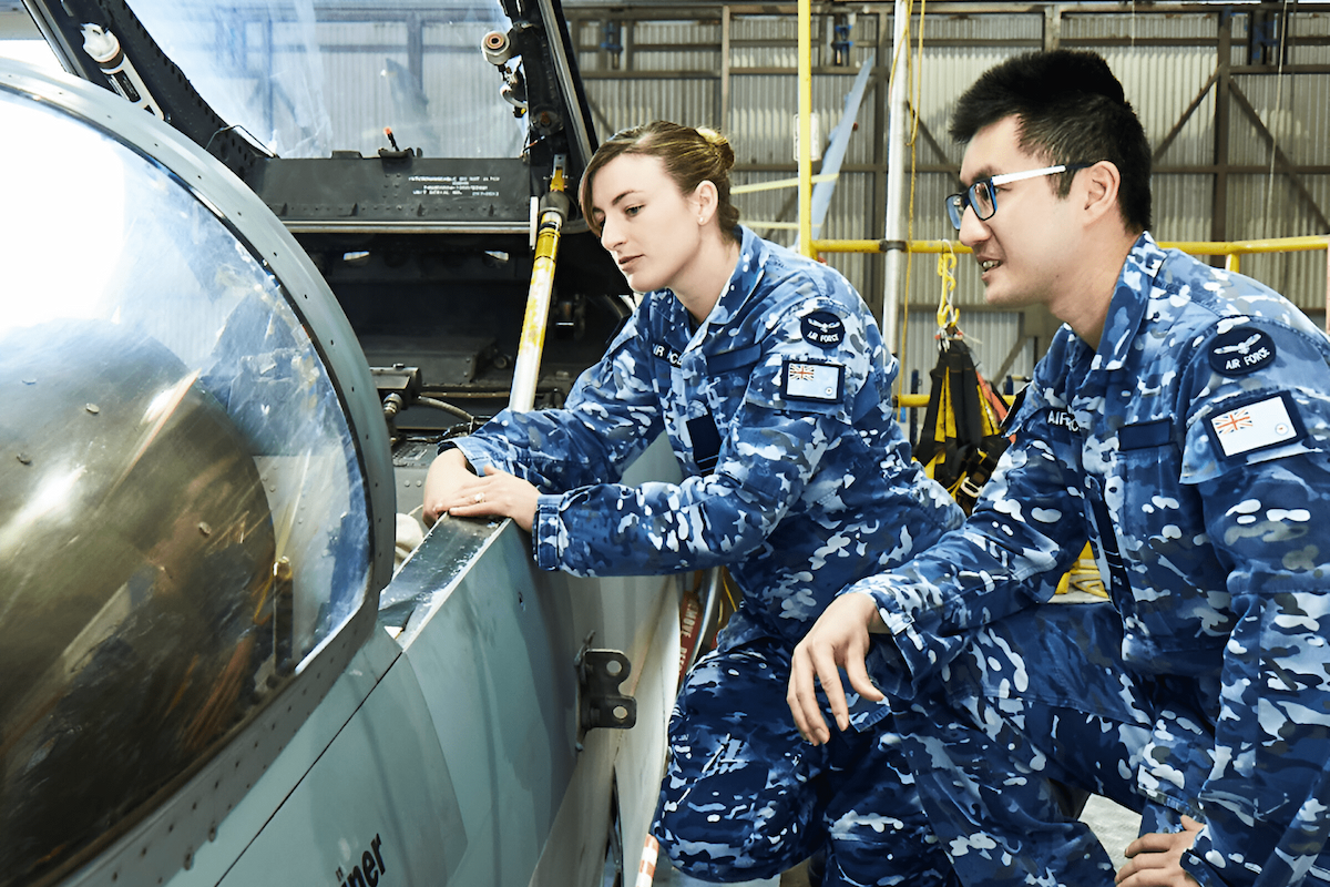 Two members of the Air Force are inspecting an aircraft.