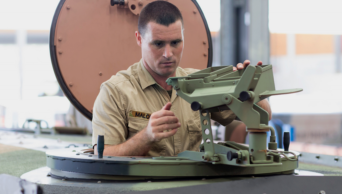 A member of the Army works on a tank.