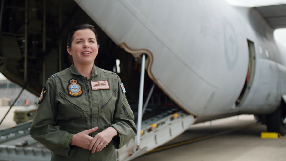 An Air Force member standing outside next to an airplane.