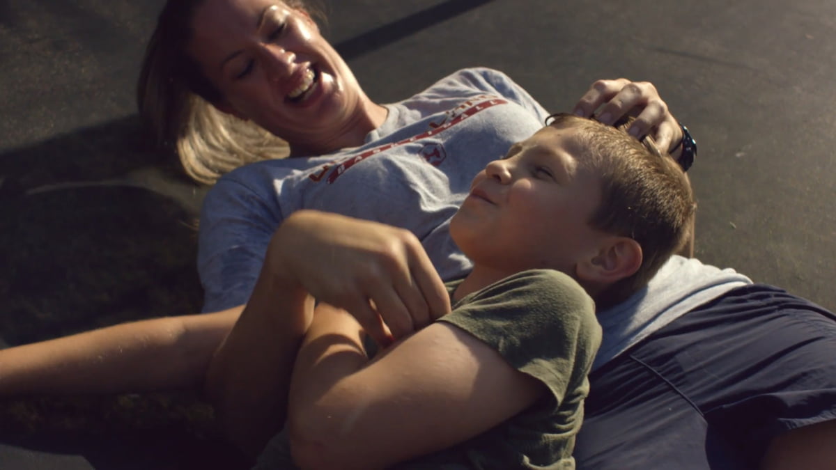 A mother and son laying down laughing together.