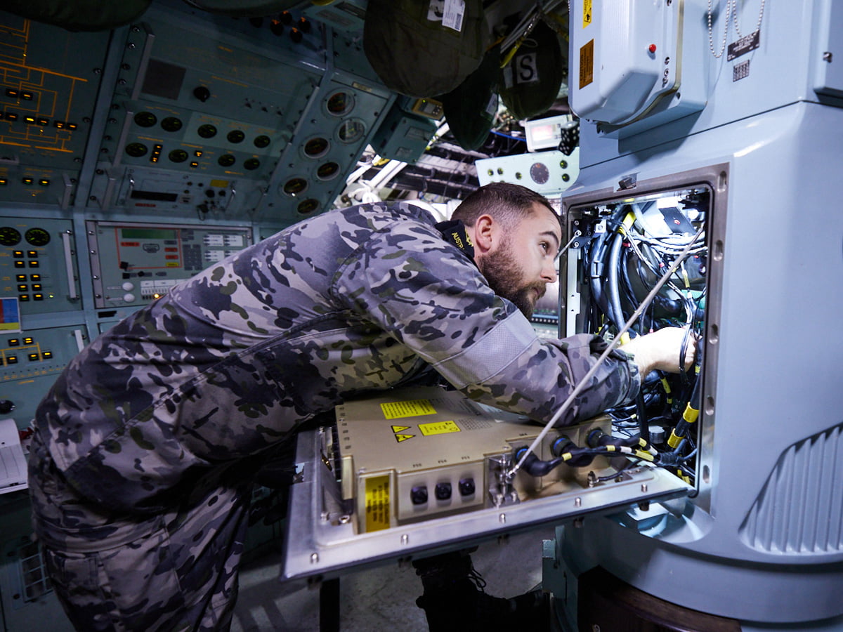 Navy Engineer performs maintenence on a complex system.