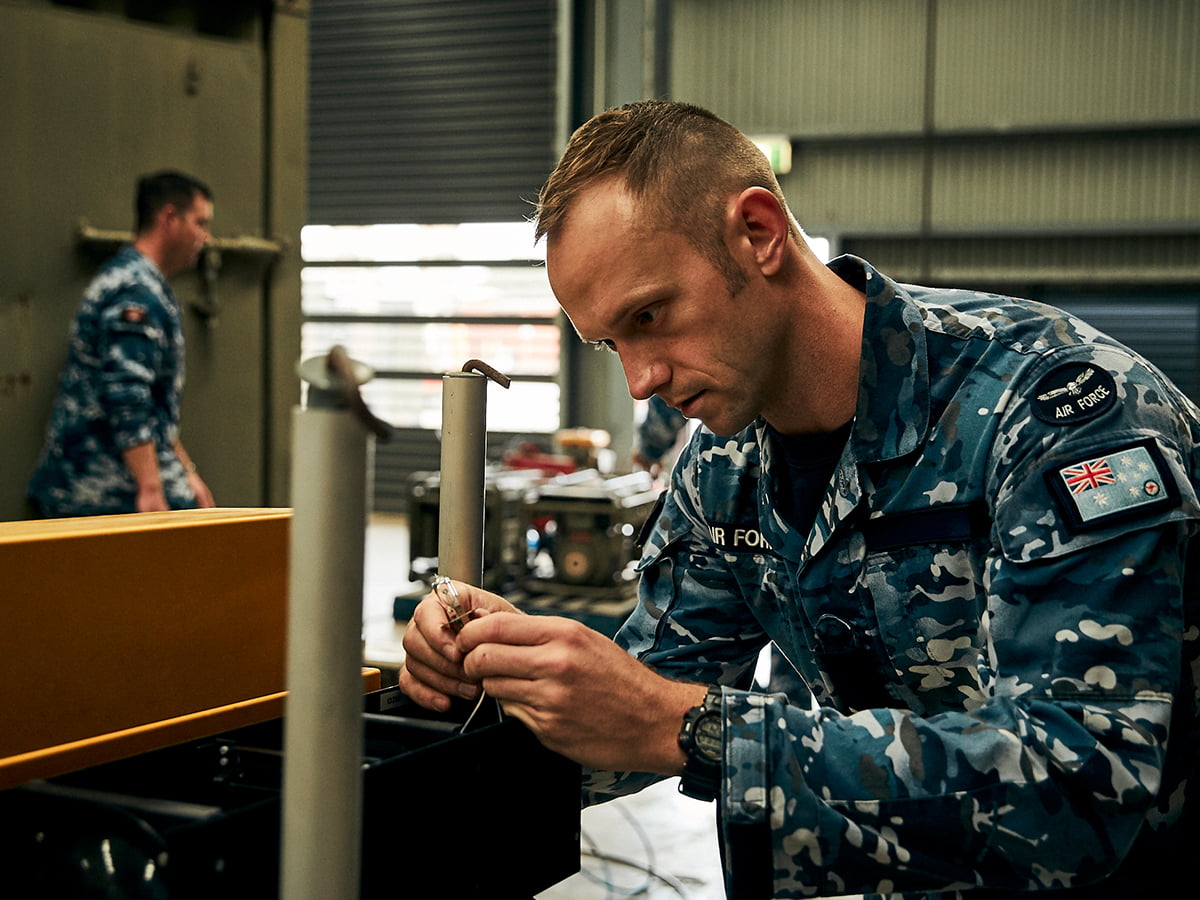 Air Force electrician performs maintenence on electrical equipment.