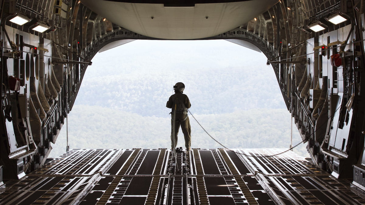 An Air Force member standing in an open aircraft.