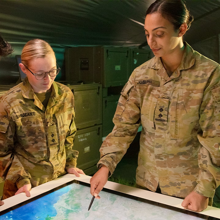 Two female members of the Army study maps.